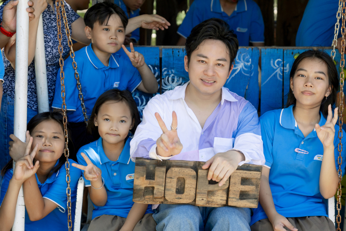 Tùng Dương bên các học sinh của trường. Ảnh: Hope School