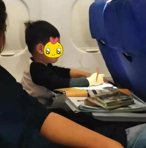 Hình ảnh em bé chăm chỉ học tập trên máy bay